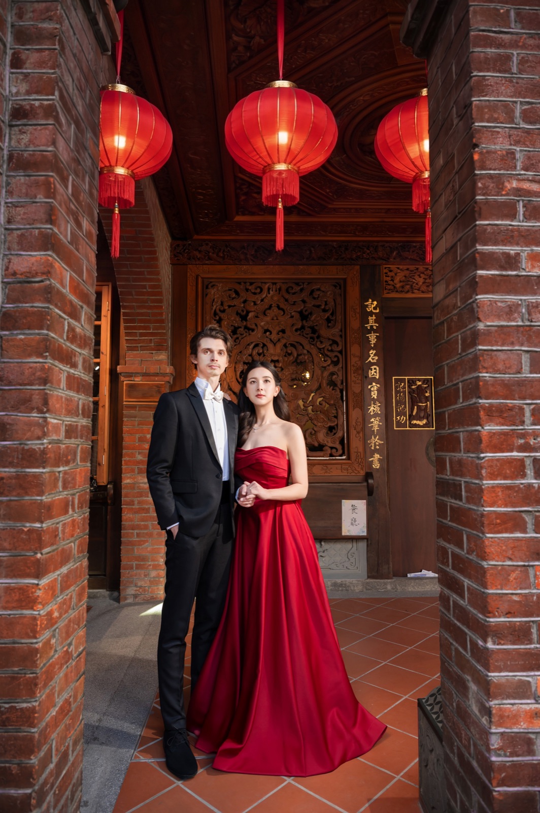 Cece and Logan under red lanterns at a Taiwan temple